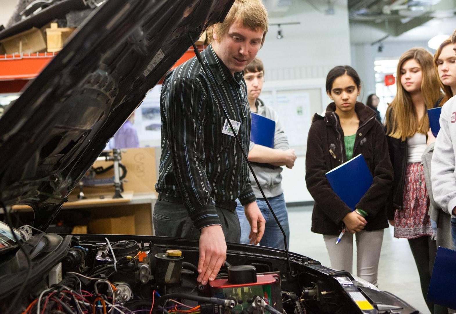 A student shows off a project to an audience.